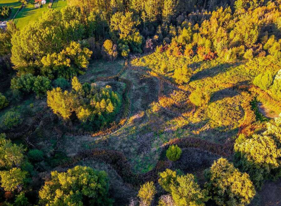 Experience the beauty of nature with this stunning aerial view of a property bathed in golden hour light.