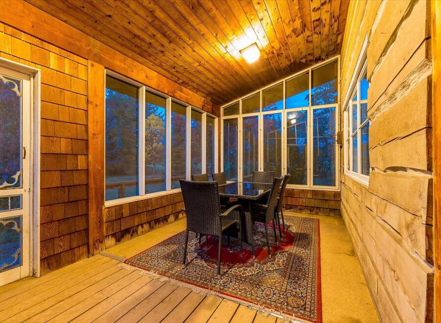 Enjoy the outdoors from this charming screened-in porch, perfect for al fresco dining or relaxing with a view.