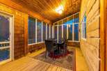 Enjoy the outdoors from this charming screened-in porch, perfect for al fresco dining or relaxing with a view.