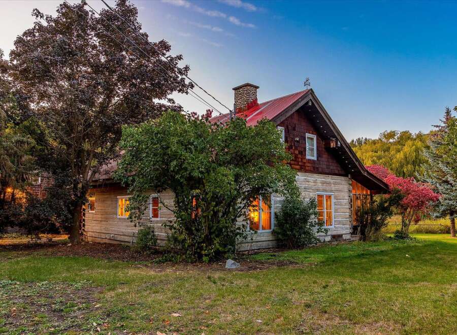 Experience the charm of this rustic log cabin, nestled amidst mature trees and vibrant foliage.