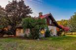 Experience the charm of this rustic log cabin, nestled amidst mature trees and vibrant foliage.