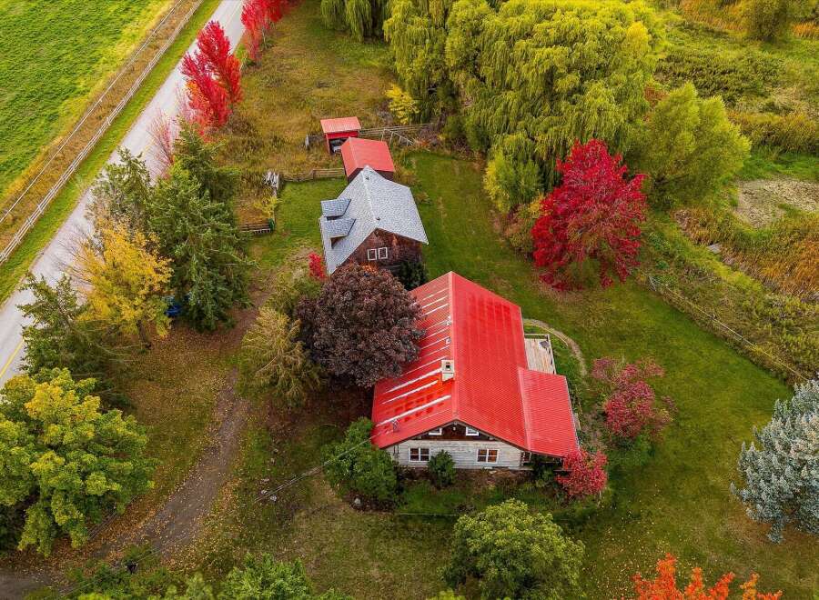 Experience the charm of autumn with this stunning aerial view of a rural property.