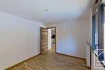 This spacious room features a modern wooden door leading to an adjacent kitchen area.