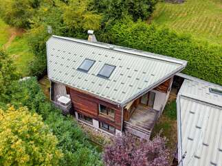 Discover this charming wooden chalet nestled amidst lush greenery, perfect for a serene mountain getaway.