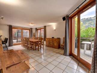This spacious dining area features a large wooden table with chairs, perfect for family gatherings.
