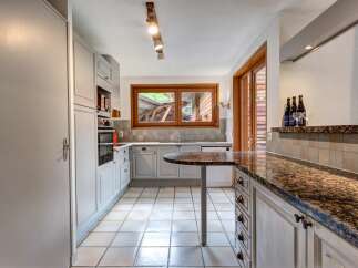 This charming kitchen features light gray cabinetry and a granite-topped island, perfect for meal preparation and casual dining.