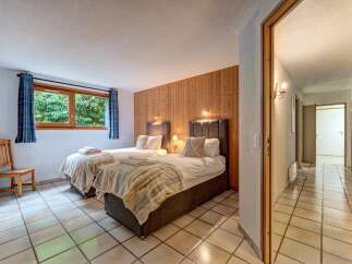 This charming bedroom features two twin beds with plush headboards, perfect for a comfortable stay.