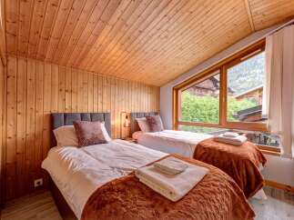 Experience cozy mountain living in this charming bedroom featuring two twin beds, perfect for families or friends.