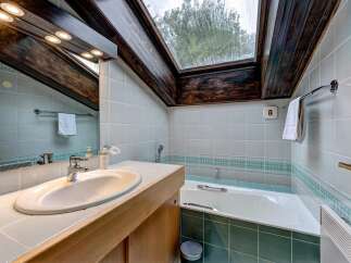 This charming bathroom features a spacious bathtub and a modern vanity with a sleek sink.