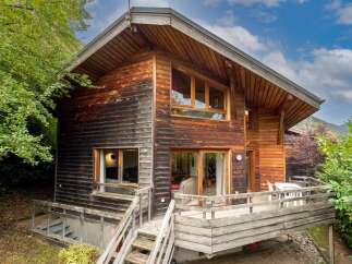Experience rustic charm in this beautiful wooden chalet, nestled amidst lush greenery.