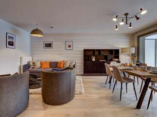 Experience modern living in this beautifully appointed open-plan space, featuring a cozy living area with a plush sofa and accent chairs, perfect for relaxation.