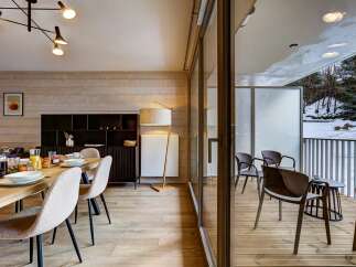 Experience modern living in this beautifully appointed dining and living area, featuring a sleek black shelving unit and a stylish floor lamp.
