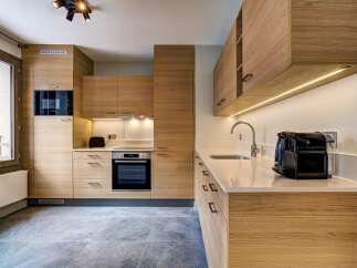 Experience modern living in this sleek kitchen, featuring warm wood cabinetry and integrated appliances.