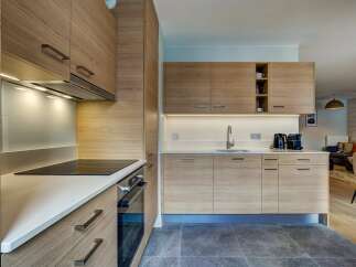 Experience modern living in this beautifully designed kitchen, featuring sleek, light wood cabinetry and a clean, white countertop.