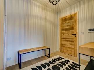 Step into this inviting entryway, featuring a warm wooden door and a sleek bench perfect for removing shoes.