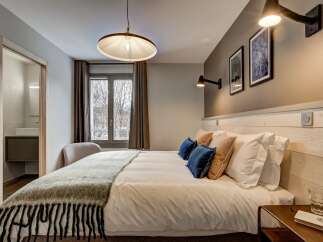 Experience comfort and style in this beautifully appointed bedroom, featuring a plush king-sized bed adorned with crisp white linens and decorative pillows.
