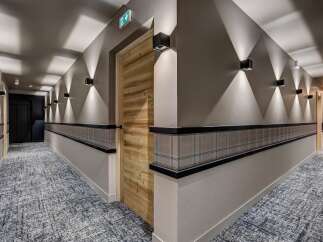 Experience the elegance of this hotel hallway, featuring a modern design with warm wood accents and sophisticated lighting.