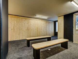 Discover this spacious changing room featuring a long wall of light wood lockers, perfect for storing gear.