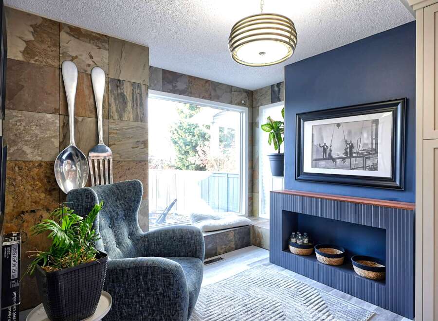 Step into a uniquely designed living space featuring a striking slate tile accent wall adorned with oversized decorative cutlery.