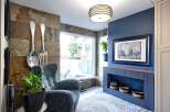 Step into a uniquely designed living space featuring a striking slate tile accent wall adorned with oversized decorative cutlery.