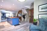 This open-concept living space features a vibrant blue kitchen island with a butcher block countertop, perfect for meal prep and casual dining.