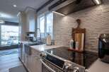 Experience the heart of this home with a beautifully updated kitchen, featuring sleek white cabinetry and a stunning mosaic tile backsplash.