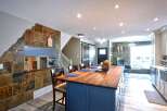 This open-concept living space boasts a stunning slate tile accent wall that adds a rustic charm to the modern design.