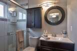 This modern bathroom features a sleek glass-enclosed shower with tiled walls and a convenient towel rack.