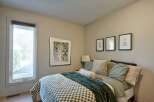 This cozy bedroom features a comfortable bed adorned with plush green bedding and a textured throw.