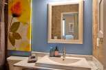 This bathroom features a modern white sink set into a marble countertop, complemented by a sleek chrome faucet.