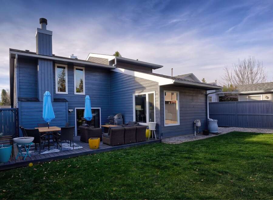 Enjoy outdoor living in this spacious backyard featuring a multi-level deck with comfortable seating and dining areas, perfect for entertaining.