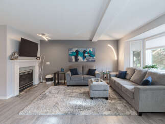 Step into this inviting living room, featuring a modern fireplace and a large flat-screen TV mounted above.