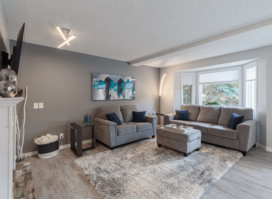 Step into this inviting living room, featuring a plush gray sectional sofa and a matching loveseat, perfect for family gatherings.