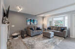 Step into this inviting living room, featuring a plush gray sectional sofa and a matching loveseat, perfect for family gatherings.