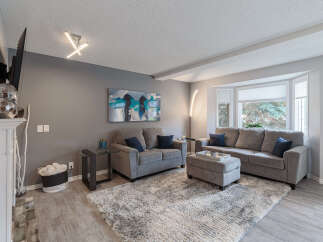 Step into this inviting living room, featuring a plush gray sectional sofa and a matching loveseat, perfect for family gatherings.