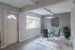 Step into a welcoming dining area featuring a sleek glass-top dining table with modern grey chairs, perfect for intimate gatherings.