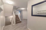 Step into this inviting entryway featuring a grand staircase with white spindles and a plush carpet runner.