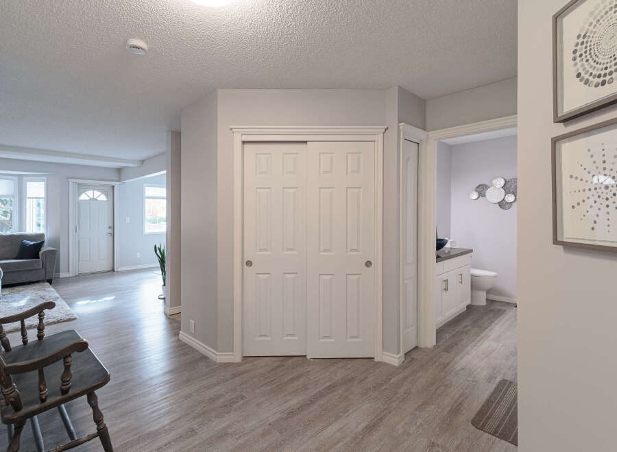 Step into a welcoming entryway featuring a stylish dark wood bench and a plush rug, perfect for greeting guests.