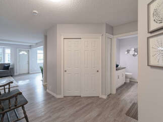 Step into a welcoming entryway featuring a stylish dark wood bench and a plush rug, perfect for greeting guests.