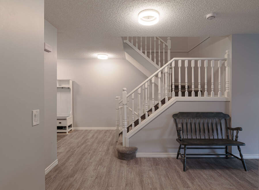 Step into a welcoming entryway featuring a white coat rack with bench seating, perfect for organizing shoes and outerwear.