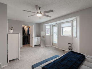 Step into this spacious master bedroom, featuring a large walk-in closet and a private balcony accessible through a glass door.