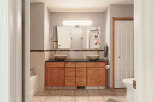 This spacious bathroom features a double vanity with vessel sinks and granite countertops, complemented by ample wooden cabinetry for storage.