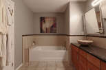 This bathroom features a luxurious soaking tub with a tiled surround and a decorative mosaic border, perfect for relaxation.