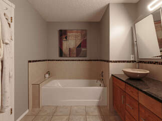 This bathroom features a luxurious soaking tub with a tiled surround and a decorative mosaic border, perfect for relaxation.