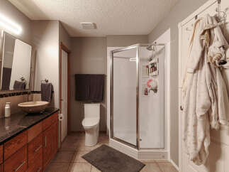 This bathroom features a modern design with a sleek vanity and a vessel sink, complemented by a spacious glass-enclosed shower.