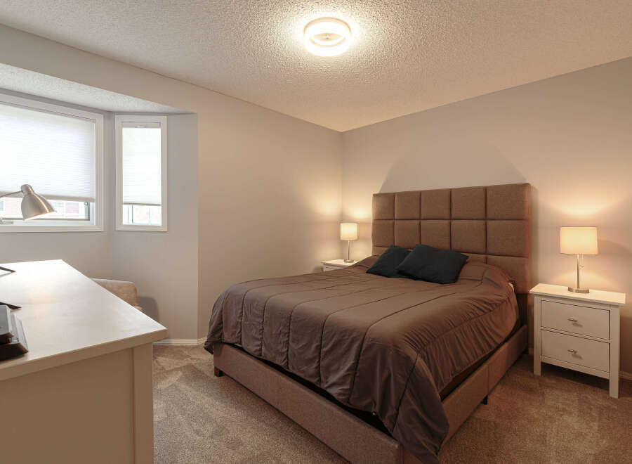 Experience comfort and style in this inviting bedroom, featuring a plush queen-size bed with a sophisticated upholstered headboard.
