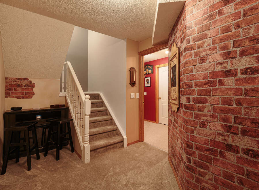 This inviting space features a cozy bar area with dark wood stools, perfect for entertaining.