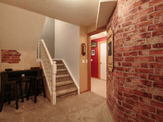 This inviting space features a cozy bar area with dark wood stools, perfect for entertaining.