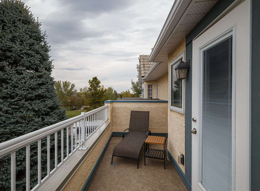 Enjoy your morning coffee or evening relaxation on this private balcony, complete with a comfortable chaise lounge and a convenient side table.