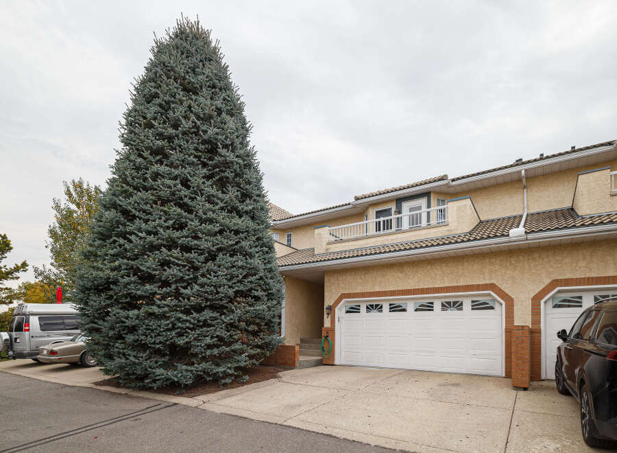 Discover this charming townhouse featuring a stucco exterior and a tiled roof, offering a welcoming facade.